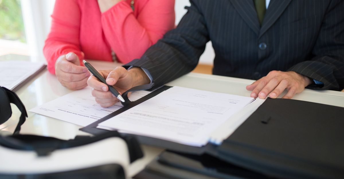 Conseiller et cliente relisant un contrat en cours lors d un rendez-vous